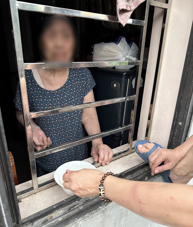 X&ocirc;n xao th&ocirc;ng tin cụ b&agrave; ở H&agrave; Nội "bị nhốt trong nh&agrave; của m&igrave;nh", con đưa cơm qua cửa sổ: Ch&iacute;nh quyền n&oacute;i g&igrave;? - Ảnh 1.