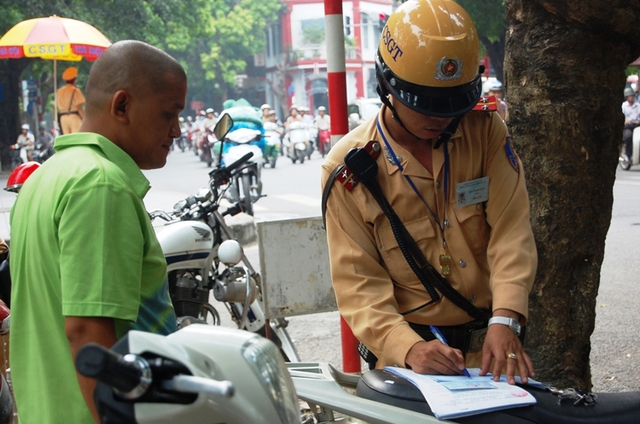 	CSGT lập biên bản người vi phạm luật giao thông.