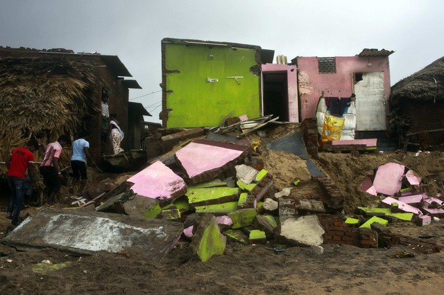 Người dân kiểm tra những ngôi nhà bị hư hại sau lốc xoáy ở Puri, Ấn Độ.