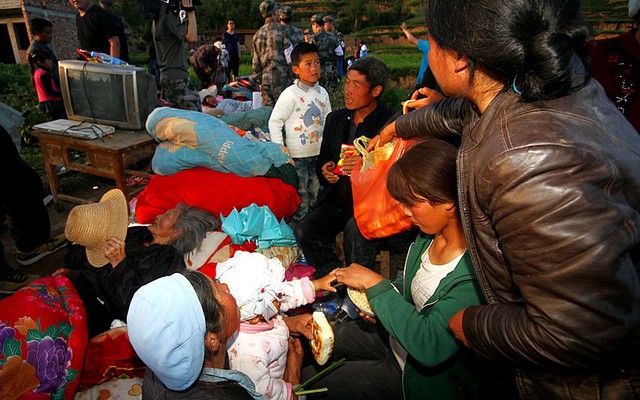 Mọi người ăn mì sống sau tại một bãi đất rộng sau khi nhà của họ bị phá hủy bởi trận động đất ở thành phố Định Tây thuộc tỉnh Cam Túc, Trung Quốc.