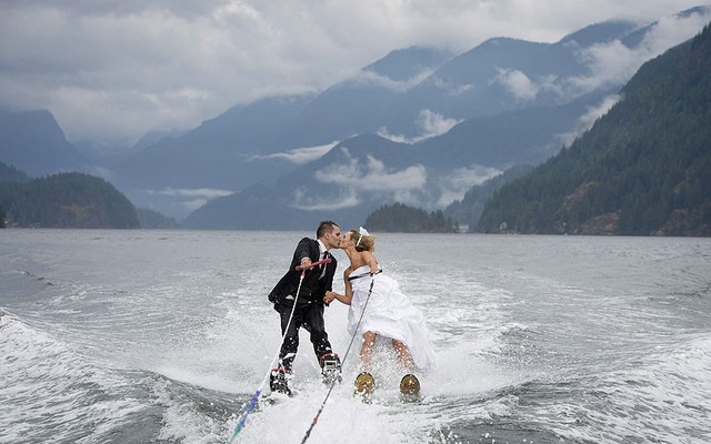 Một cặp đội hôn nhau trong khi lướt ván trong lễ cưới của họ trên vịnh Bedwell ở North Vancouver, Canada.