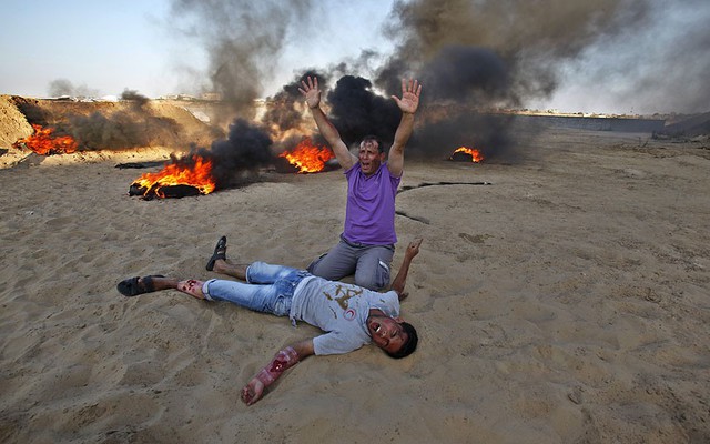 Các sinh viên trường y của Palestin đóng vai nạn nhân của một vụ nổ đang cứu trong khi diễn tập tại lễ tốt nghiệp ở Mughraqa, Dải Gaza.