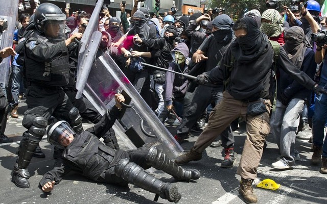 Những người biểu tình đụng độ với cảnh sát chống bạo động ở thủ đô Mexico city, Mexico.