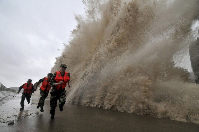 Binh sĩ chạy tránh sóng bão Fitow dữ dội đánh vào bờ gần thành phố Ôn Lĩnh, tỉnh Chiết Giang, Trung Quốc.