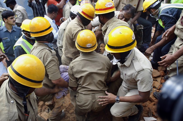 Các nhân viên cứu hộ đưa một thi thể khỏi đống đổ nát của ngôi nhà bị sập ở Bangalore, Ấn Độ.