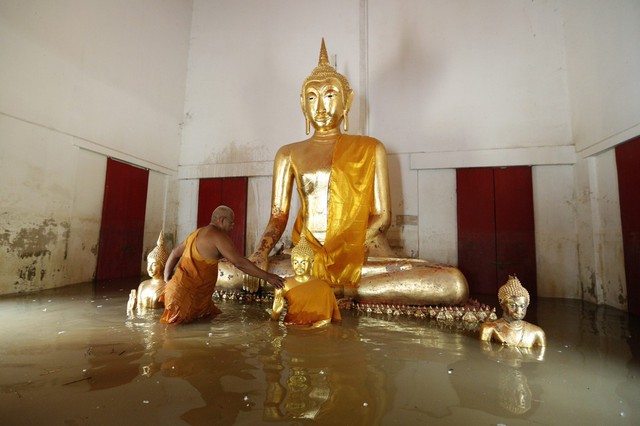 Nhà sư lội trong nước lũ tại một ngôi chùa ở tỉnh Ayutthaya, Thái Lan.