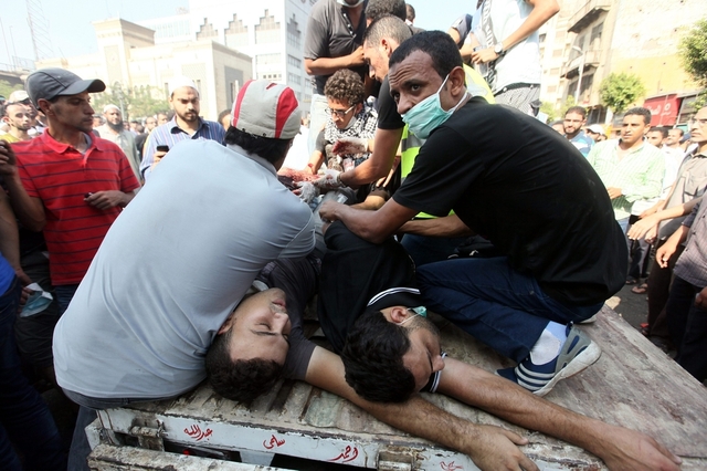 Những người biểu tình sơ cứu cho những đồng đội bị thương trong cuộc đụng độ với cảnh chống bạo động gần quảng trường Ramses, Cairo, Ai Cập.