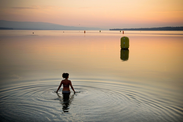 Một phụ nữ tắm lúc ban mai dưới hồ Geneva ở thành phố Geneva, Thụy Sĩ.