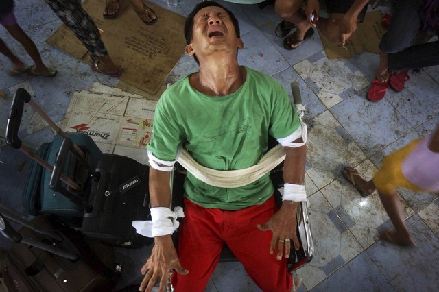 Gerardo Alvarez, 53 tuổi, nhăn mặt khi bị buộc ngồi trong xe lăn tại một căn cứ không quân ở Cebu, Philippines. Alvarez bị bệnh hoang tưởng vài ngày sau khi mẹ và em gái của ông bị thiệt mạng do siêu bão Haiyan.