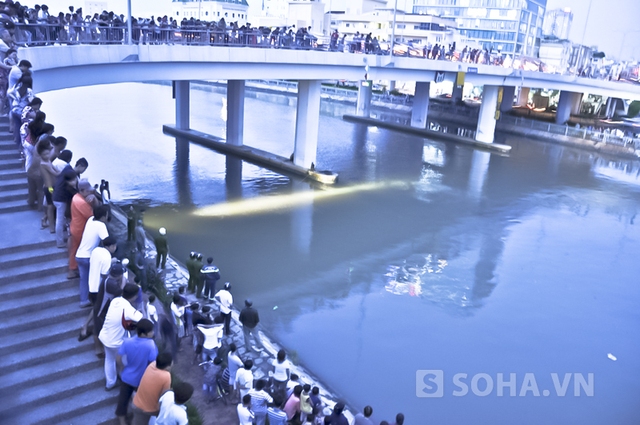 Hàng trăm người hiếu kỳ tụ tập trên cầu xem người nhái mò xác nạn nhân.