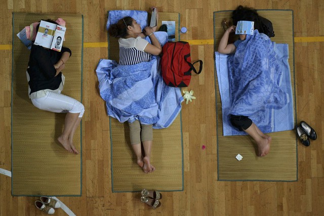 Các phụ huynh đưa con đi nhập học ngủ trong nhà thi đấu thể thao tại trường đại học Hoa Trung ở thành phố Vũ Hán, Trung Quốc.