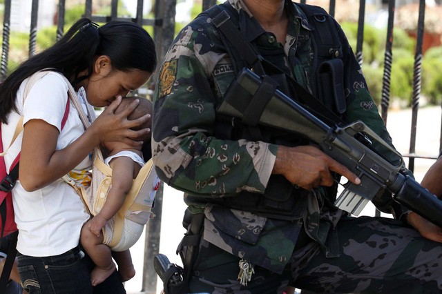 Một bà mẹ hôn con nhỏ trong khi chờ được sơ tán khỏi một ngôi làng tại thành phố Zamboanga, Philippines, khi các cuộc giao tranh giữa quân đội chính phủ và phiến quân Hồi giáo đang diễn ra ác liệt tại đây.