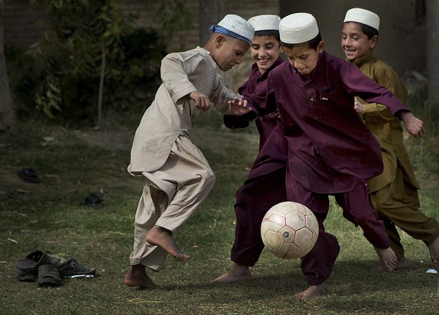 Học sinh cùng nhau chơi bóng đá trong giờ nghỉ tại trường ở ngoài ô Kandahar, Afghanistan.