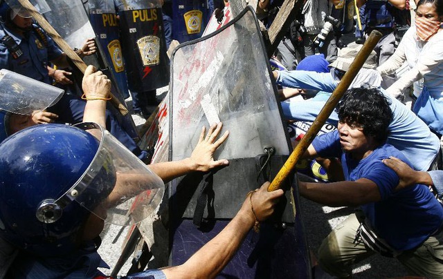 Người dân đụng độ với cảnh sát chống bạo động khi đôi giải tỏa phá dỡ nhà của họ tại khu ổ chuột ở thành phố Quezon, Philippines.