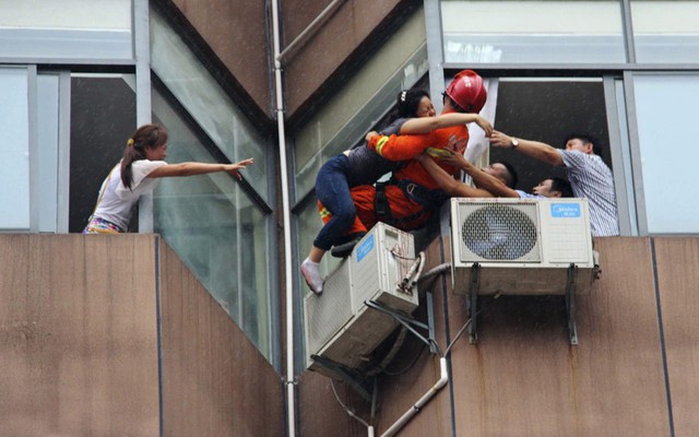 Lính cứu hỏa cứu một phụ nữ cắt cổ tay rồi chèo qua cửa sổ phòng khách sạn trên tầng 7 để định nhảy lầu tự tử ở thành phố Đồng Nhân, tỉnh Quý Châu, Trung Quốc.