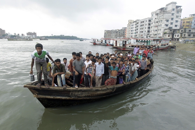 Công nhân may qua sông trên một chiếc thuyền quá tải ở Dhaka, Bangladesh.