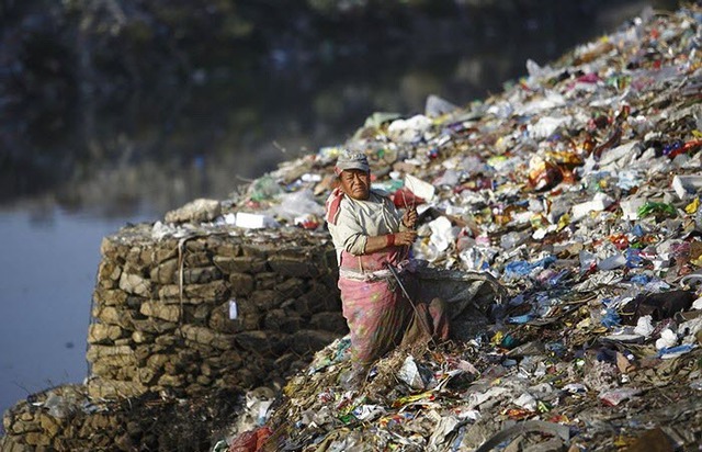 Một phụ nữ nhặt những thứ có thể tái chế tại một bãi rác trên bờ sông Bagmati ở Kathmandu, Nepal.