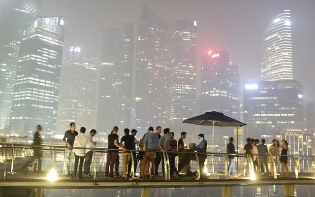 Các tòa nhà cao tầng ở Singapore bị bao phủ bởi một lớp sương khói mờ ảo do cháy rừng ở Indonesia. Hình ảnh được chụp từ khách sạn Marina Bay Sands, Singapore.