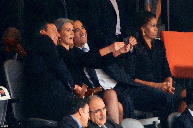 Tổng thống Mỹ Barack Obama và Thủ tướng Anh David Cameron nghiêng người chụp hình cùng Thủ tướng Đan Mạch Helle Thorning Schmidt, trong khi Đệ nhất phu nhân Michelle Obama tỏ ra không hài lòng. Hình ảnh được chụp tại tang lễ của huyền thoại Nelson Mandela.