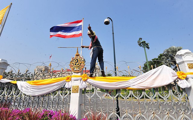 Người biểu tình trèo lên hàng rào bảo vệ bên ngoài tòa nhà chính phủ ở Bangkok, Thái Lan.