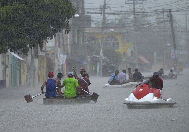 Người dân sử dụng thuyền nhỏ và cano máy để sơ tán người và tài sản khỏi khu vực ngập lụt ở Titxla de Guerrero, Mexico.