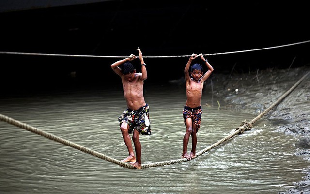 Các cậu bé đi trên dây bắc qua sông Hlaing ở Yangon, Myanmar.