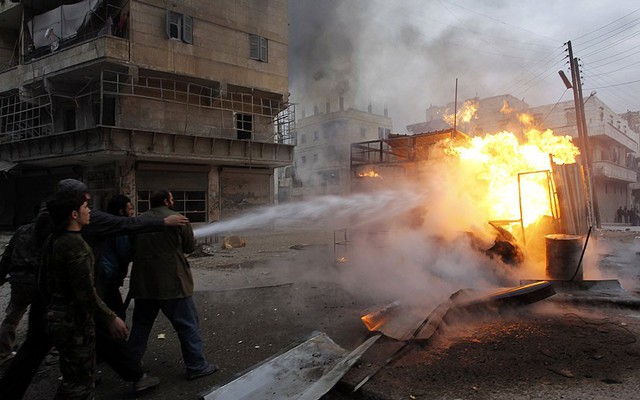 Người dân đang cố gắng dập tắt một đám cháy do đạn pháo của quân đội chính phủ gây ra ở Aleppo, Syria.
