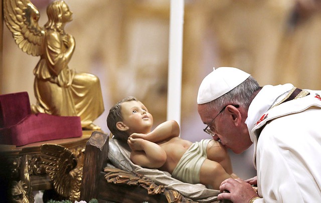 Giáo hoàng hôn tượng chúa Jesus khi nhỏ trong đêm Giáng sinh tại quảng trường St. Peter's, Vatican.