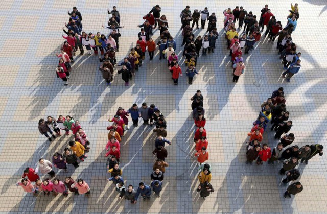 Học sinh đứng xếp hình thành chữ Happy 2014 để chào đón năm mới tại một trường học ở Mã An Sơn, tỉnh An Huy, Trung Quốc.