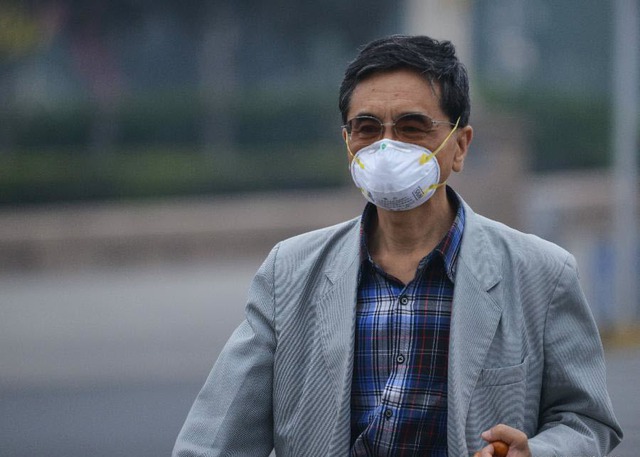 Một người đàn ông phải đeo khẩu trang phòng độc  khi đi trên đường phố Bắc Kinh, Trung Quốc, do tình trạng ô nhiễm không khí gia tăng tại thành phố này trong những ngày gần đây.