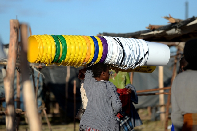 Một người phụ nữ đội những chiếc xô nhựa đi bán tại chợ Jambanja market ở Seke, Zimbabwe.