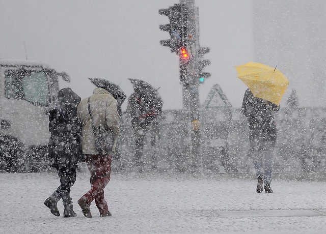 Mọi người đi dưới bão tuyết và gió mạnh ở Berlin, Đức.