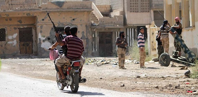 Các chiến phiên quân nạp đạn cho một súng phóng rocket tự chế tại thành phố Deir Ezzor ở Syria.
