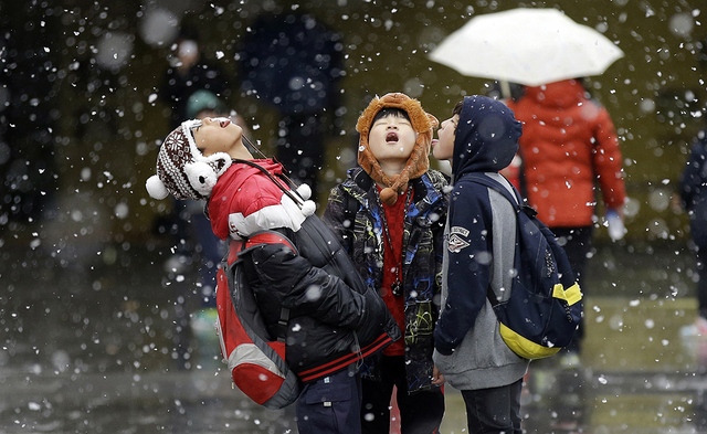 Trẻ em ngửa mặt nếm tuyết rơi tại thủ đô Seoul, Hàn Quốc.