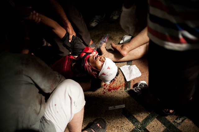Một nam thanh niên đang được sơ cứu sau khi tham gia biểu tình tại thủ đô Cairo, Ai Cập.