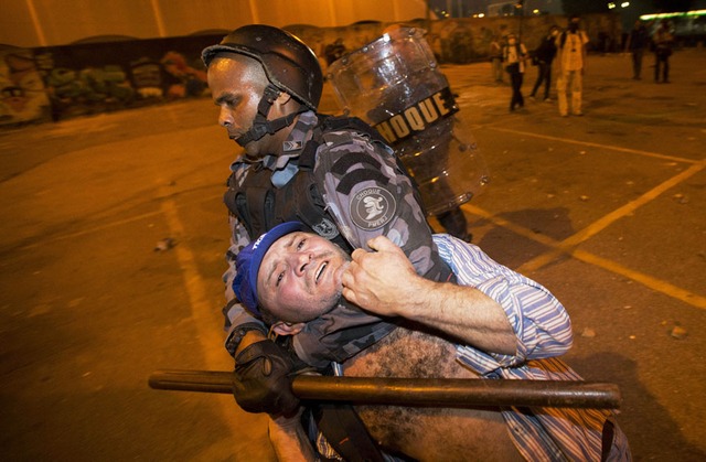 Cảnh sát bắt giữ một người biểu tình chống chính phủ ở Rio de Janeiro, Brazil.