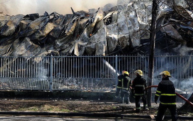 Lính cứu hỏa cố gắng dập tắt lửa trong vụ hỏa hoạn xảy ra tại nhà máy sản xuất xúc xích ở Buenos Aires, Argentina.