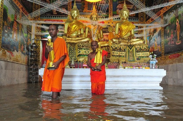 Các nhà sư ôm tượng phật trong một ngôi chùa bị ngập nước cạnh sông Chao Phraya ở tỉnh Ayutthaya, Thái Lan.