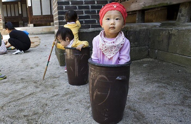 Các em bé ngồi chơi trong một bình gốm trong Lễ hội ẩm thực truyền thống của giới quý tộc và hoàng gia, tổ chức tại Cung điện Unhyeon, Seoul, Hàn Quốc.