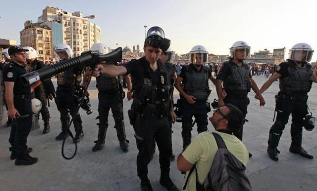 Cảnh sát chống bạo động đề nghị một phóng viên ảnh di chuyển ra khu vực khác trong cuộc biểu tình chống chính phủ ở Istanbul, Thổ Nhĩ Kỳ.