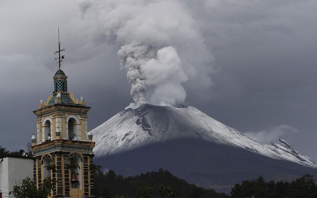 Tro bụi phun lên từ núi lửa Popocatepetl cạnh một nhà thờ ở Santiago Xalizintla, Mexico.