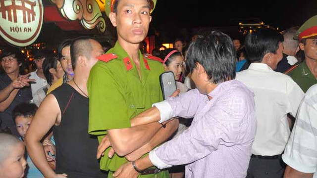 Công an tạm giữ một nghi phạm cướp giật tại Festival di sản Quảng Nam đêm 21-6. Ảnh: Tấn Vũ (Tuổi trẻ)