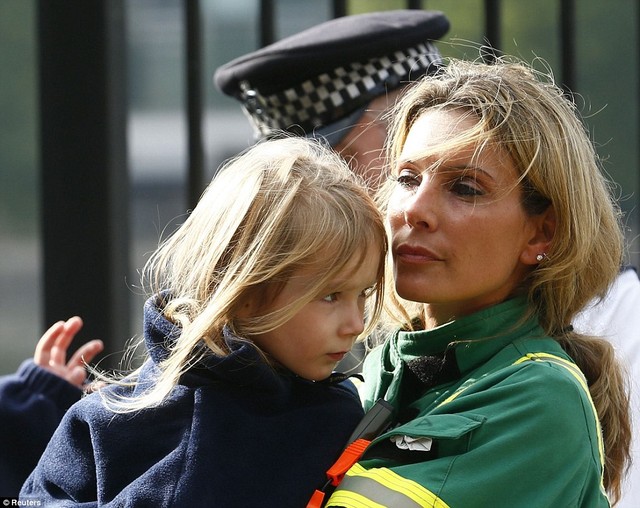 Everything's okay: A member of the London Ambulance Service holds a child rescued from the Thames after an amphibious tourist vehicle caught fire