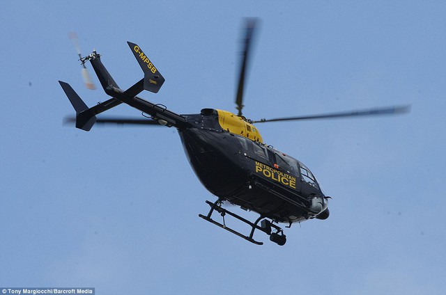 Air support: A Metropolitan Police helicopter flies above the smoking London Duck Tours amphibious vehicle on the River Thames, close to Westminster