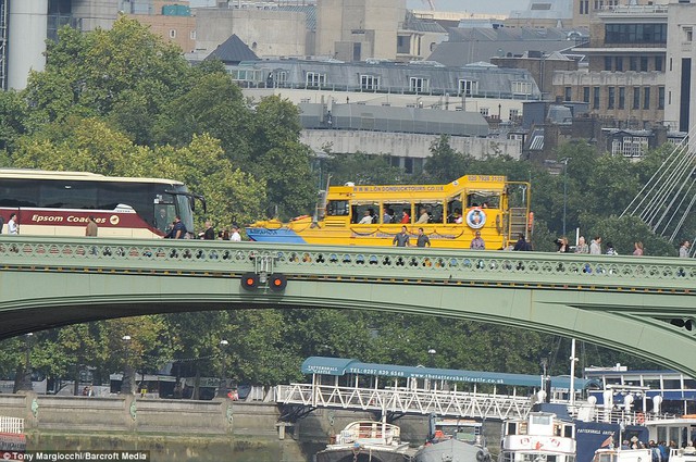 Still running: Another London Duck Tours amphibious vehicle passing over the River Thames today, just hours after the Cleopatra craft caught fire