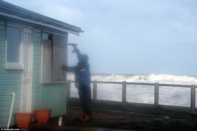 Các chế phẩm: Một cư dân địa phương trong Walcott trên miền Bắc Norfolk bảng chi phí lên một cửa sổ để giúp lưu nhà của mình trong trường hợp bị trúng thủy triều cao