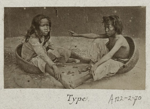  	Hai đứa trẻ làm bốc vác tại bến cảng đang chơi bên cạnh những đồng xu hiếm hoi.