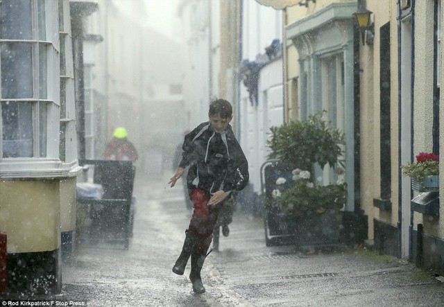 Bị bắt mà không có một chiếc ô: Một gia đình chạy cho trang bìa như mưa xối xả trong Appledore, phía Bắc Devon, đánh dấu sự bắt đầu của cơn bão sợ là tồi tệ nhất trong một thập kỷ