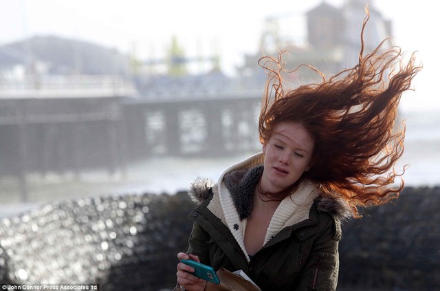 Ngày tóc xấu: mái tóc dài của một cô gái bị cuốn trong gió khi bà đi dọc theo bãi biển Brighton chiều hôm qua
