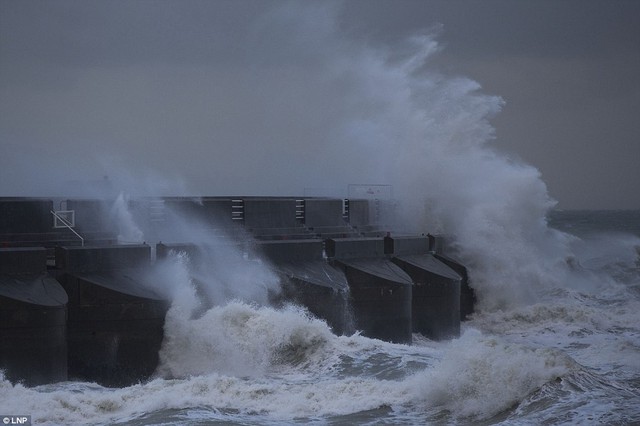 Brace mình: Sóng sụp đổ vào thành bến du thuyền ở Brighton buổi sáng ngày hôm qua.  Anh đang bị trúng gió 90mph và mưa lớn